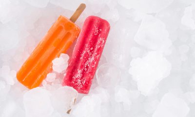 Orange mango and bright pink watermelon ice pops on a bed of ice